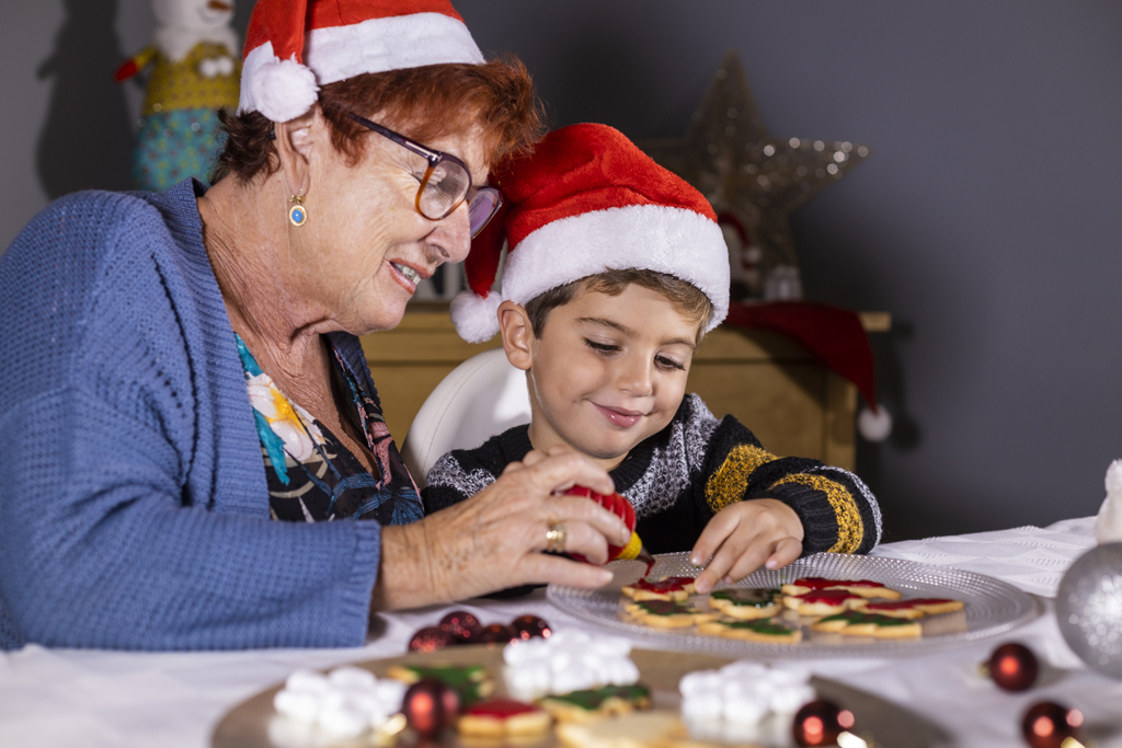 Grandmother and grandson decorating cookies